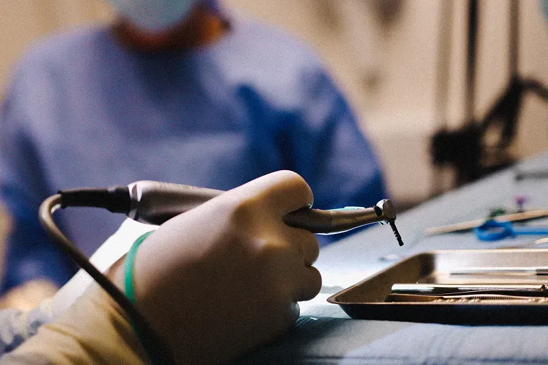 Chirurgien-dentiste préparant son matériel pour un soin dentaire.